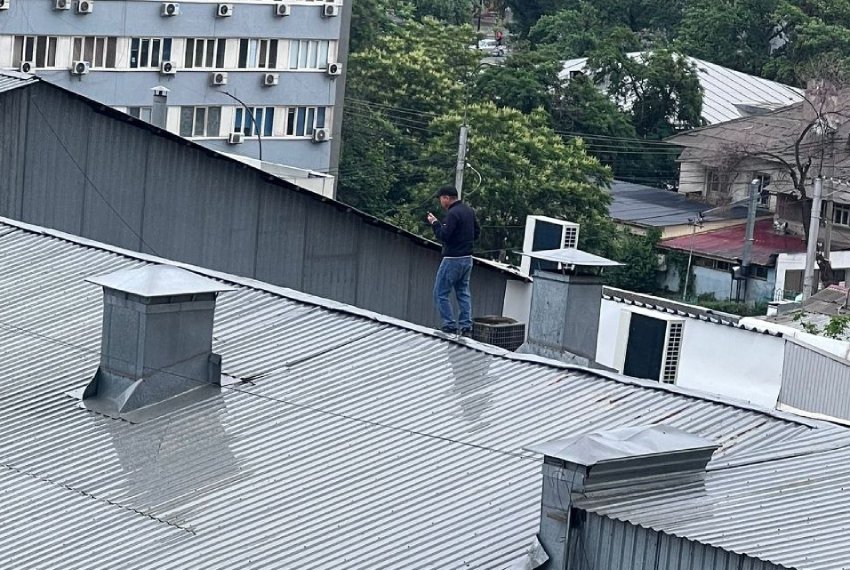 Фото читателей. Человек идет по мокрой крыше без страховки